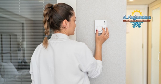 Woman adjusting her thermostat.